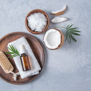 concept of organic spa flat lay. Healthy coconut oil with a wooden brush and half a coconut