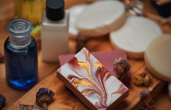 Shampoo and soap products on wooden board